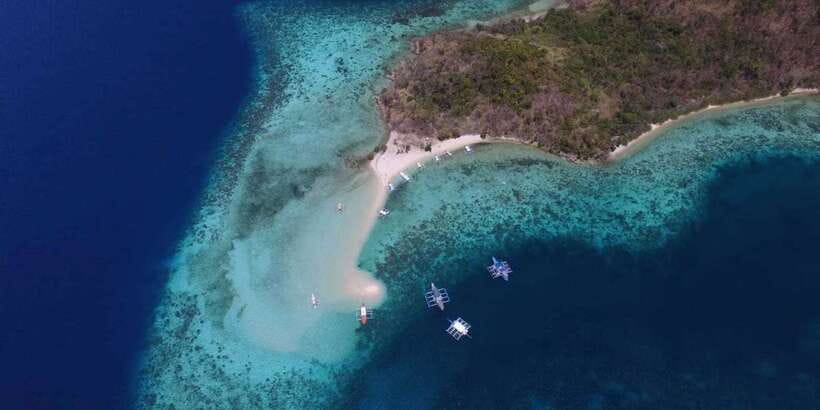 From Coron: Private Island-Hopping Cruise with Lunch - Banana Island: curved powder sand, clear water, and reef views